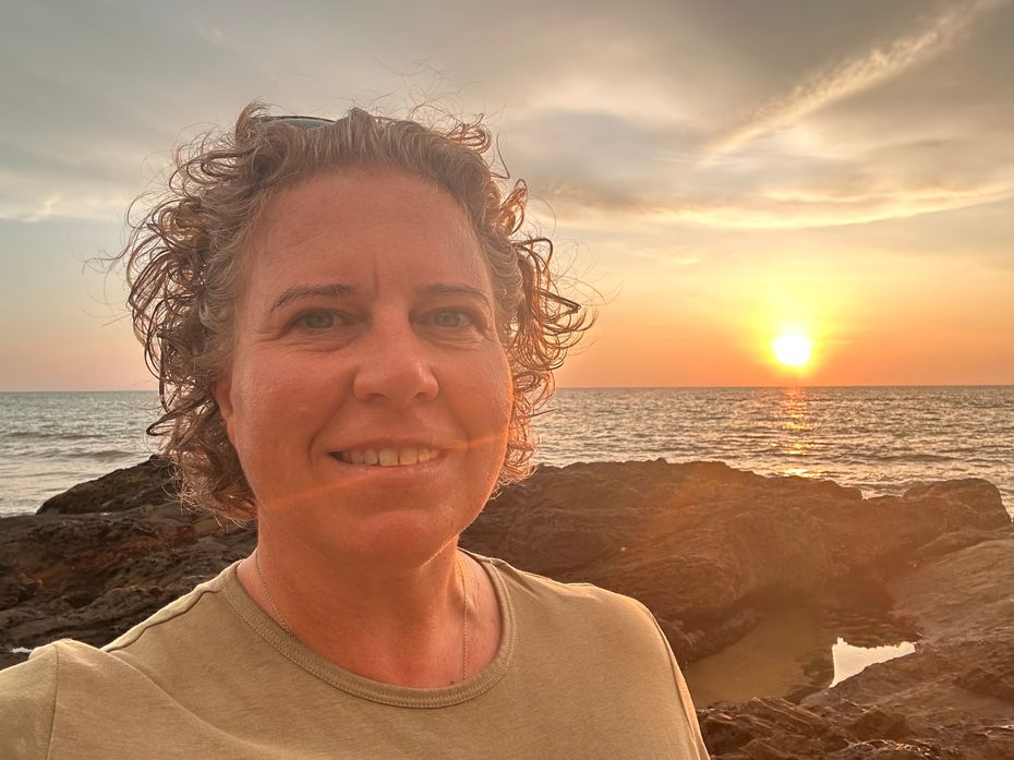 Siobhain founder of Sisters Uncharted, standing by the Ocean at sunset, embracing the Spirit of adventure.