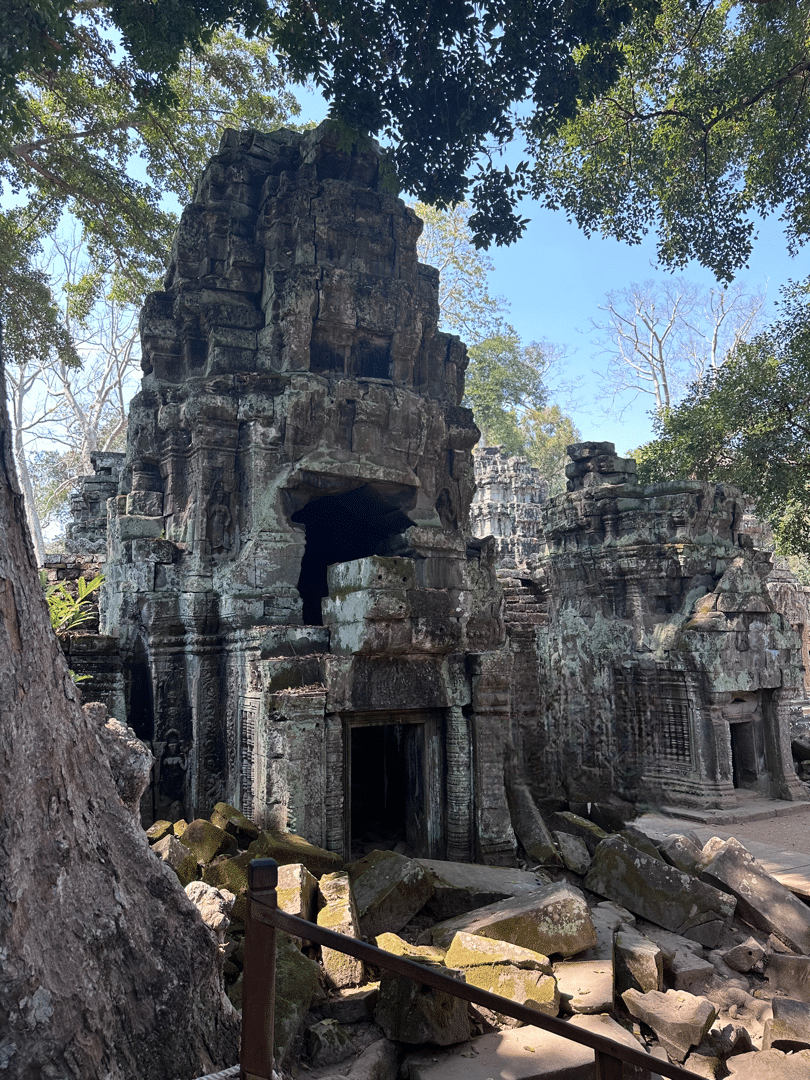 Ancient temple ruins in Siem Reap, Cambodia, surrounded by lush trees and scattered stone blocks - a must-visit site for solo travellers exploring Siem Reap