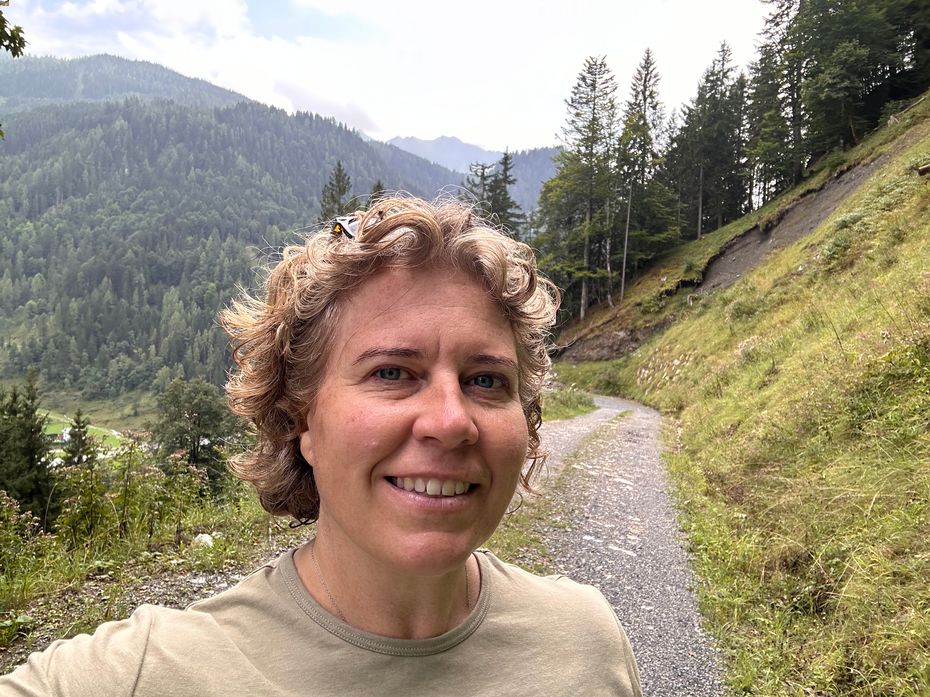 Siobhain Smith, an experienced solo traveller, smiling on a mountain path in the Austrian Alps - offering unlimited Whatsapp advice for women traveling alone